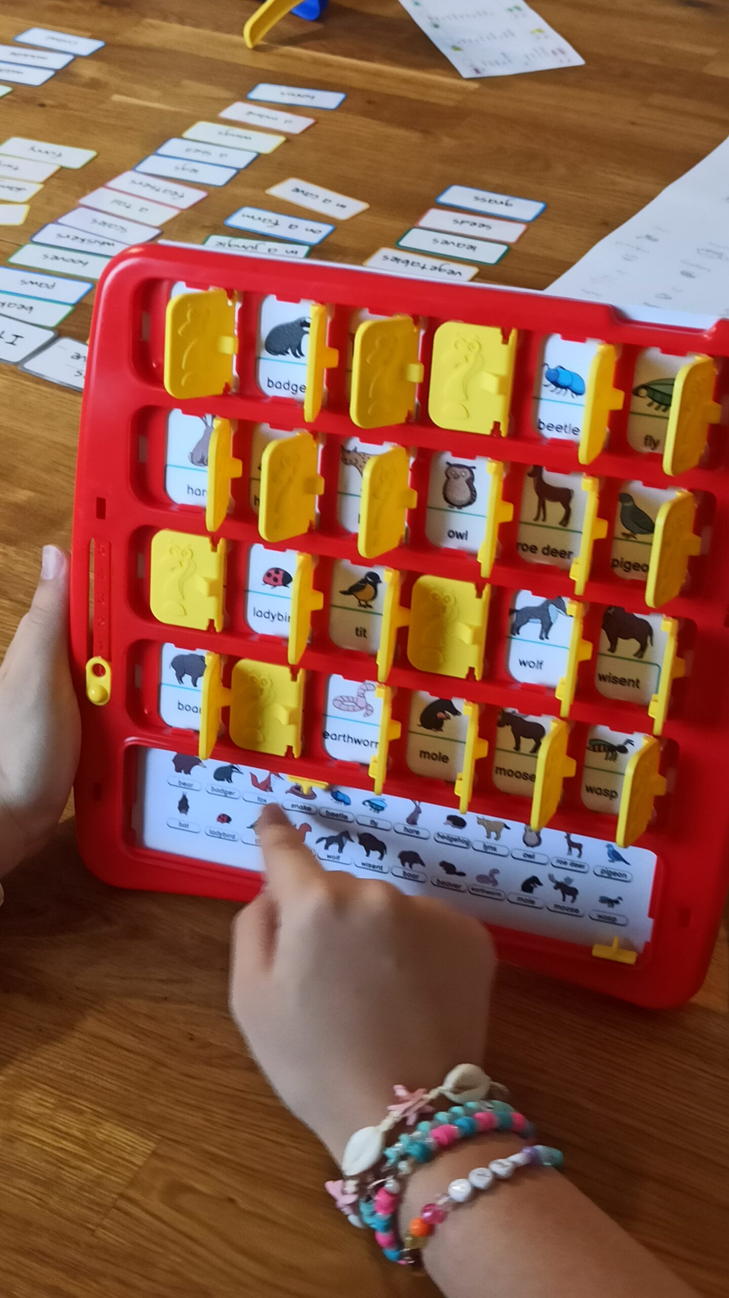 dziecko grające w edukacyjną wersję popularnej gry "Zgadnij kto to?" (Guess Who?)